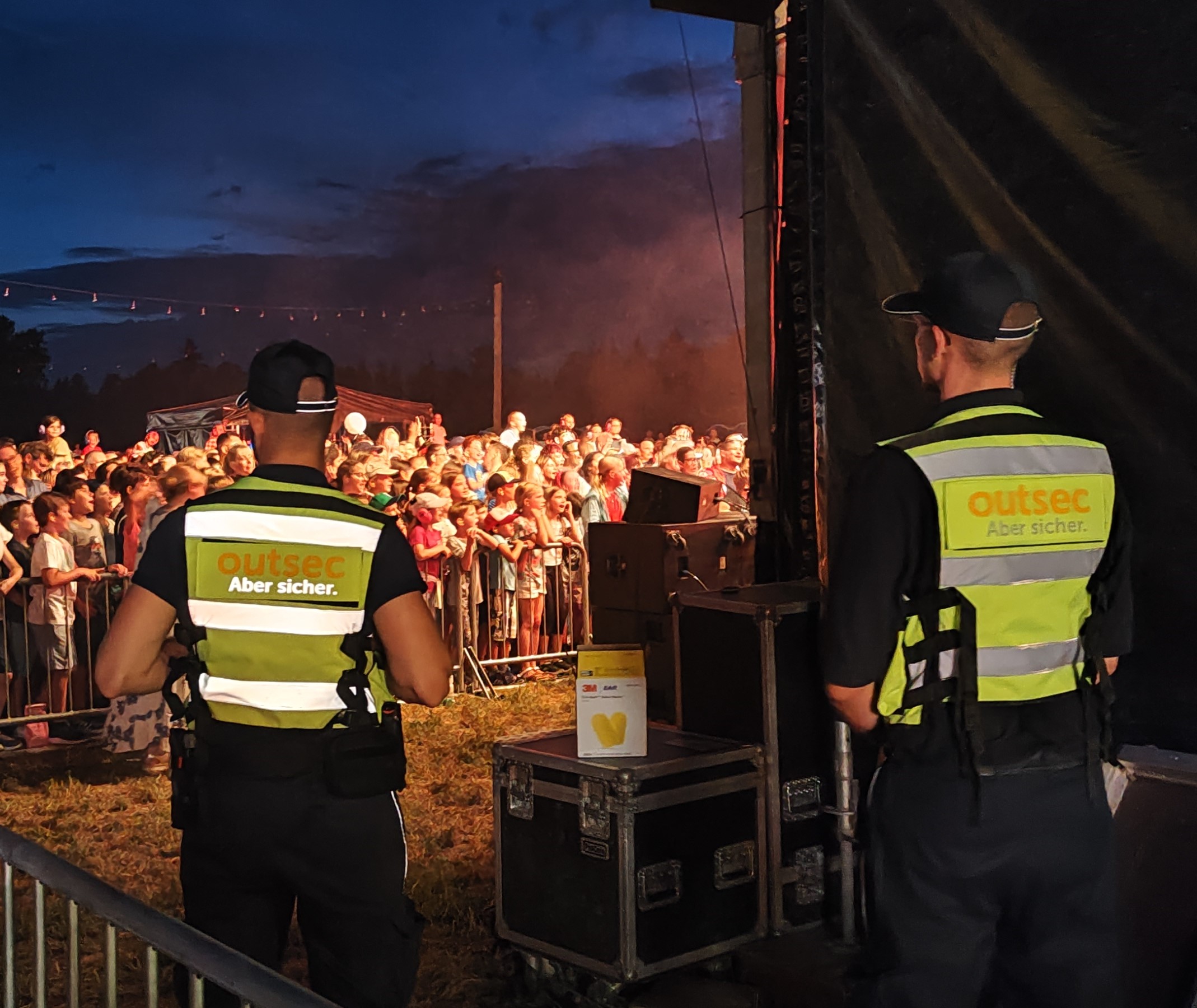 Bild von 2 Mitarbeitenden an einem Festival, die für den Veranstaltungsschutz zuständig sind.