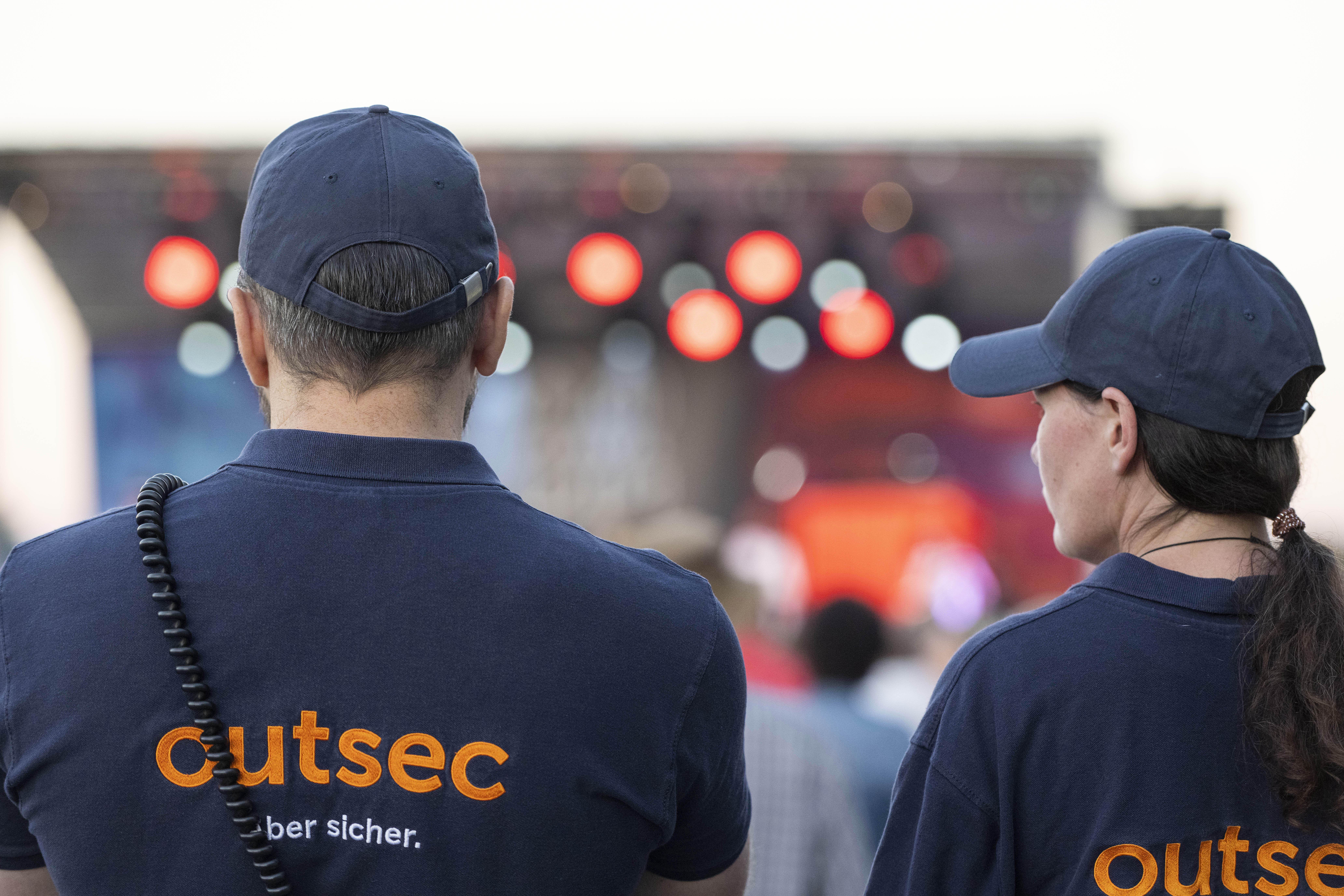 Outsec-Mitarbeitende sichern ein Konzert vor der Bühne