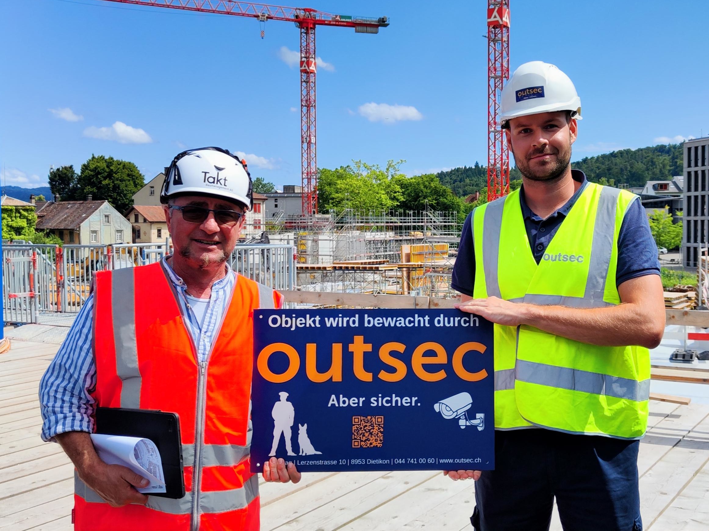 Outsec-Bauteam mit Bewachungsschild auf einer Baustelle